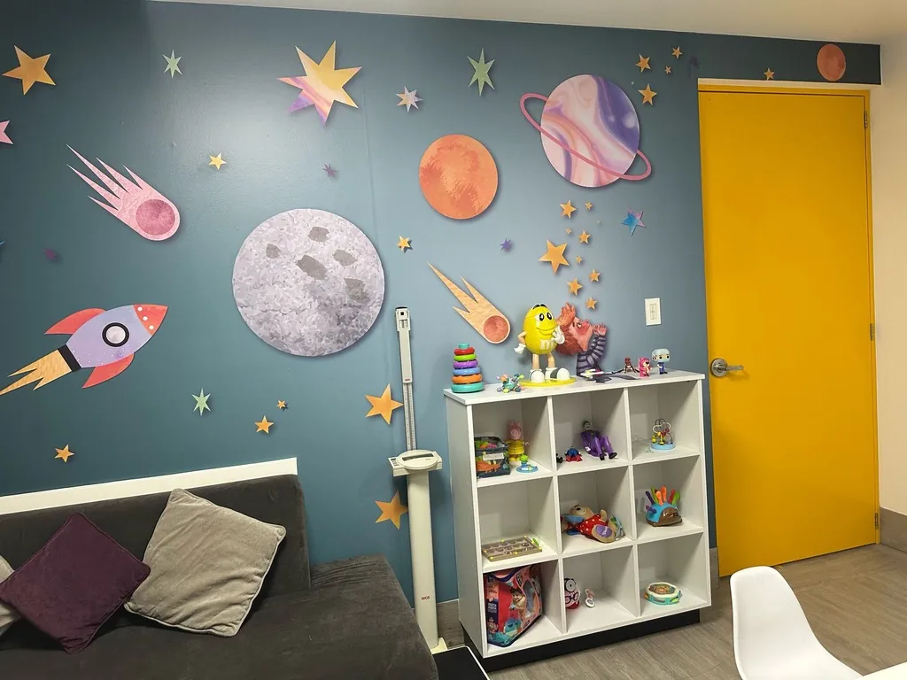 Consultorio pediátrico de KidCare decorado con planetas y cohetes