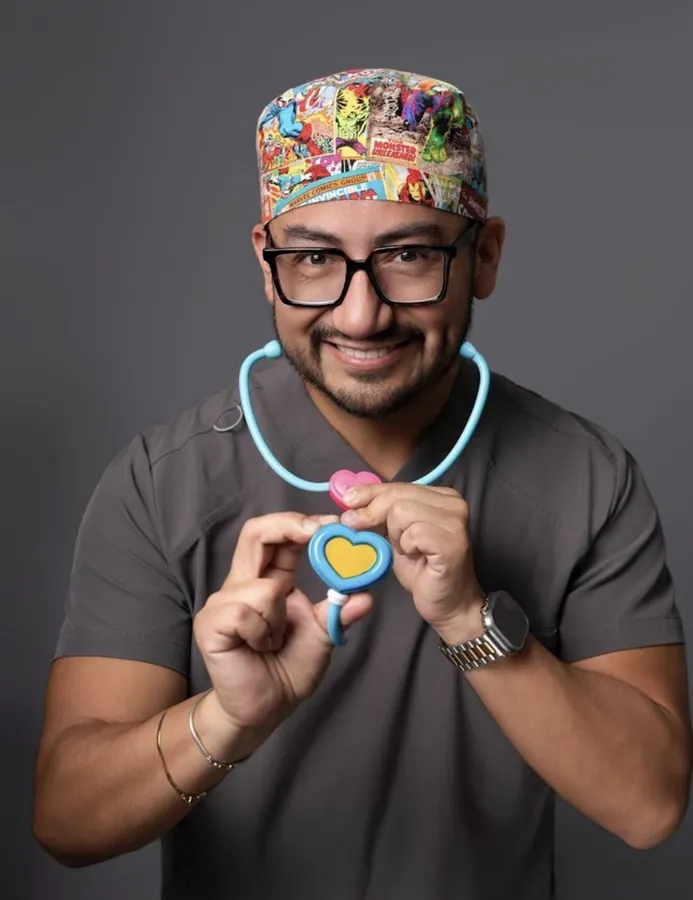 El Dr. Alex Miranda con un estetoscopio de juguete