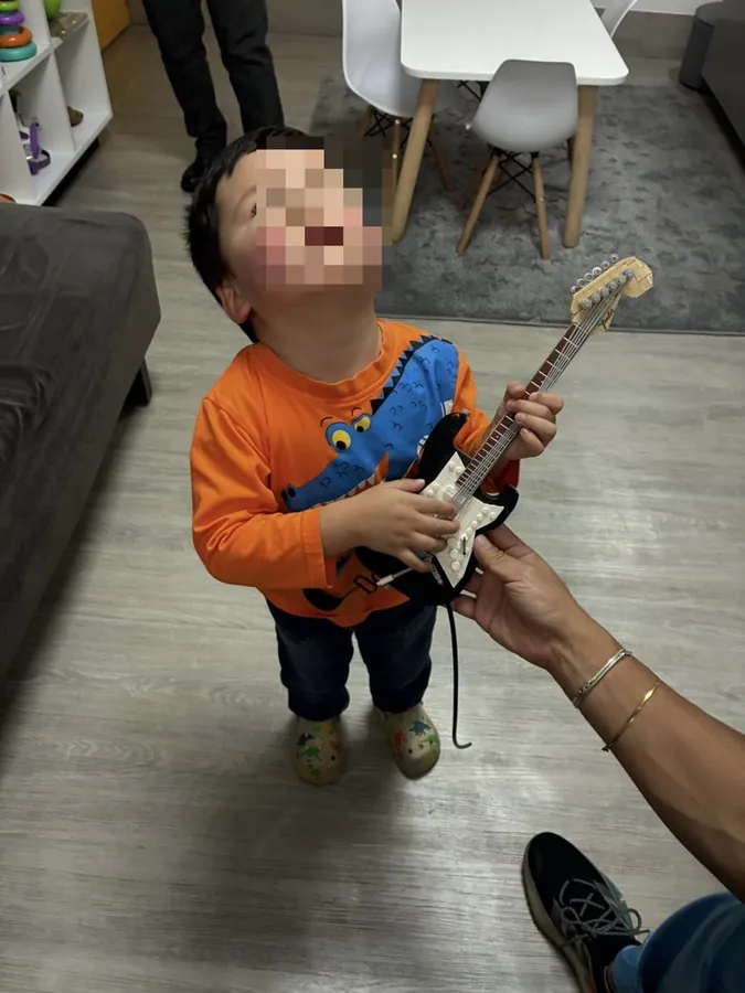 Un niño jugando con una guitarra de juguete en el consultorio