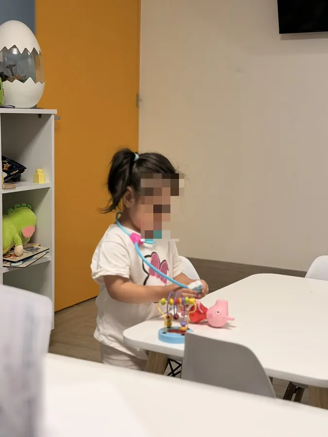 Una niña jugando al doctor en la sala de espera de KidCare