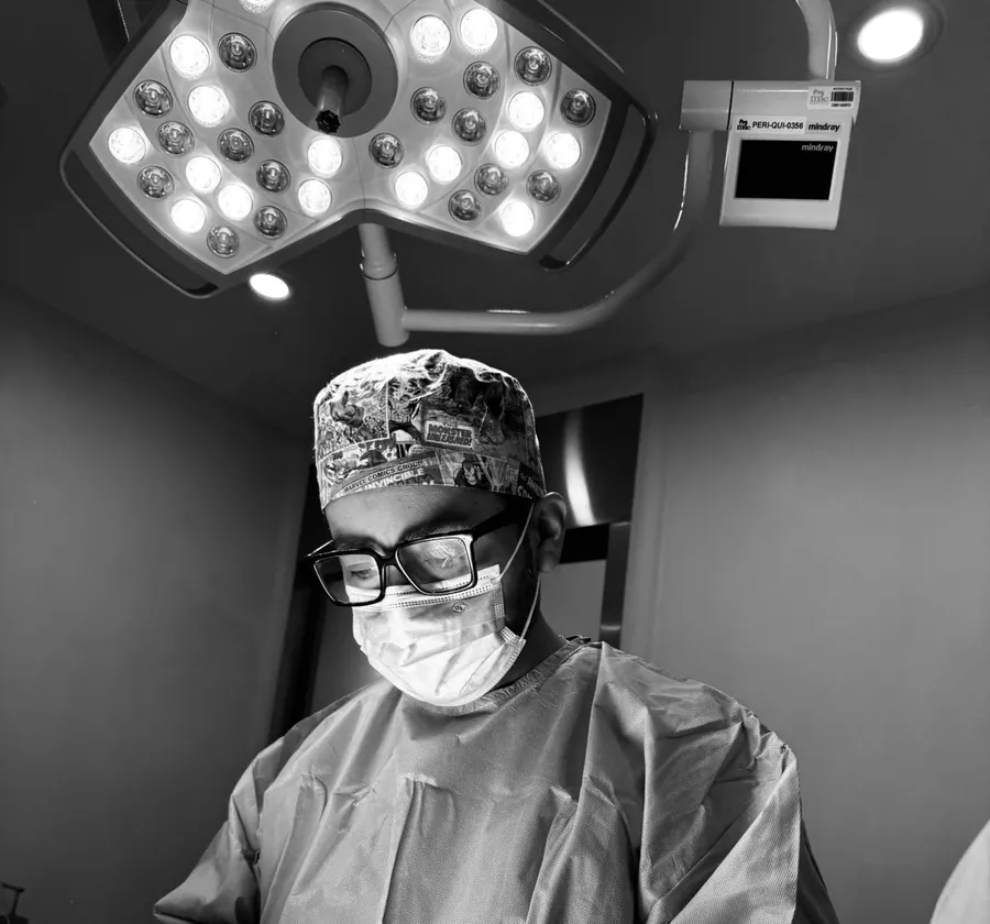 El Dr. Alex Miranda operando bajo la lámpara quirúrgica